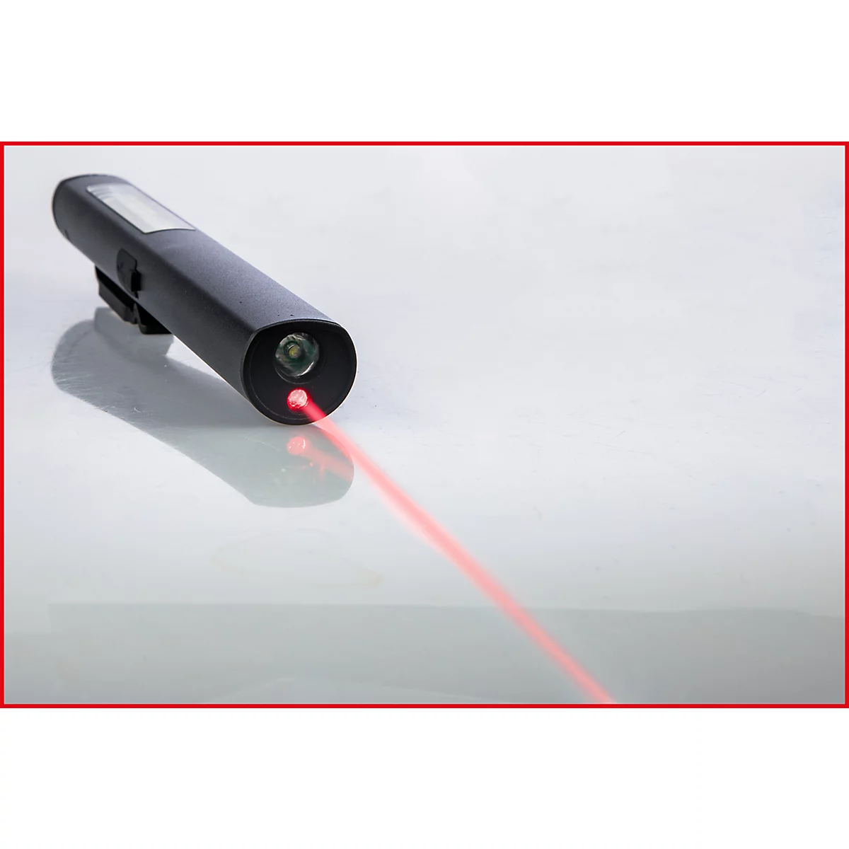 Een zwarte laserpointer-zaklamp projecteert een rode laserstraal op een glad, wit oppervlak.